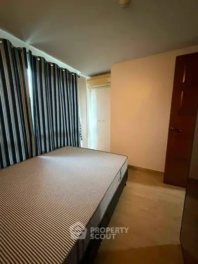 Cozy bedroom with striped curtains and air conditioning in modern apartment.