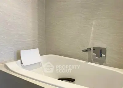 Modern bathroom with sleek bathtub and elegant fixtures in a contemporary home.