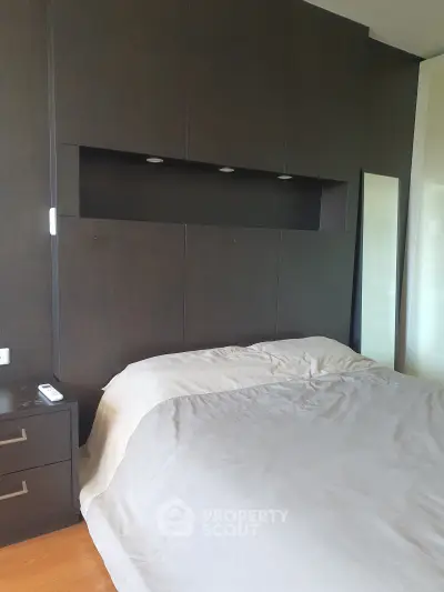 Modern bedroom with sleek dark wood paneling and cozy bedding