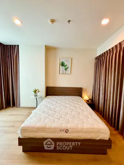 Spacious bedroom with modern decor and natural light, perfect for relaxation.