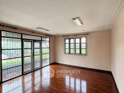Spacious empty living room with large windows and wooden flooring