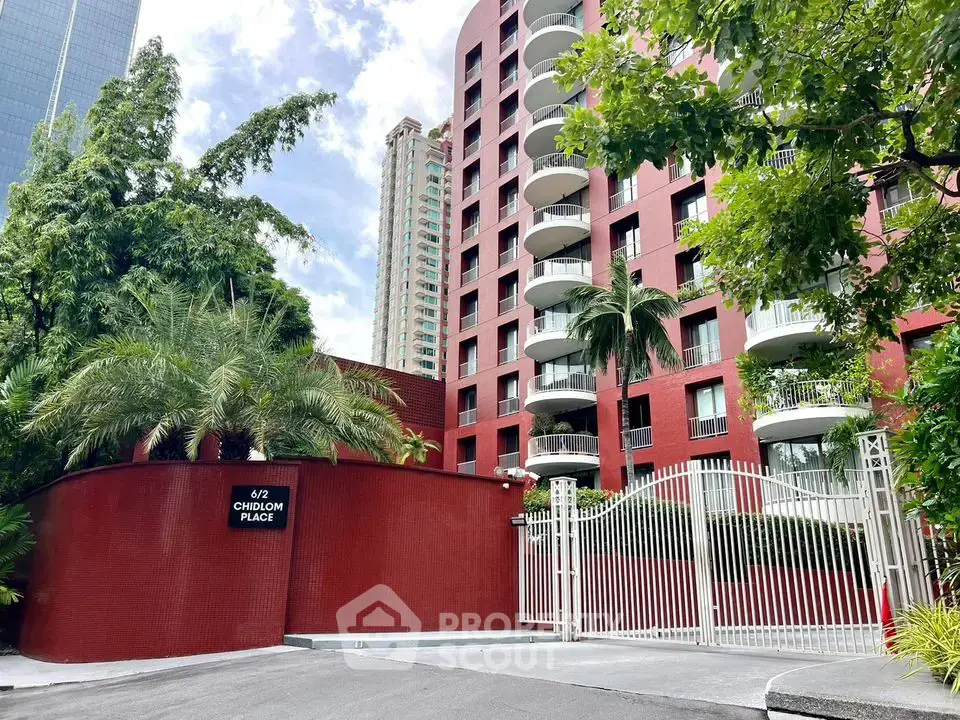 Stunning red brick apartment building with lush greenery and secure gated entrance.