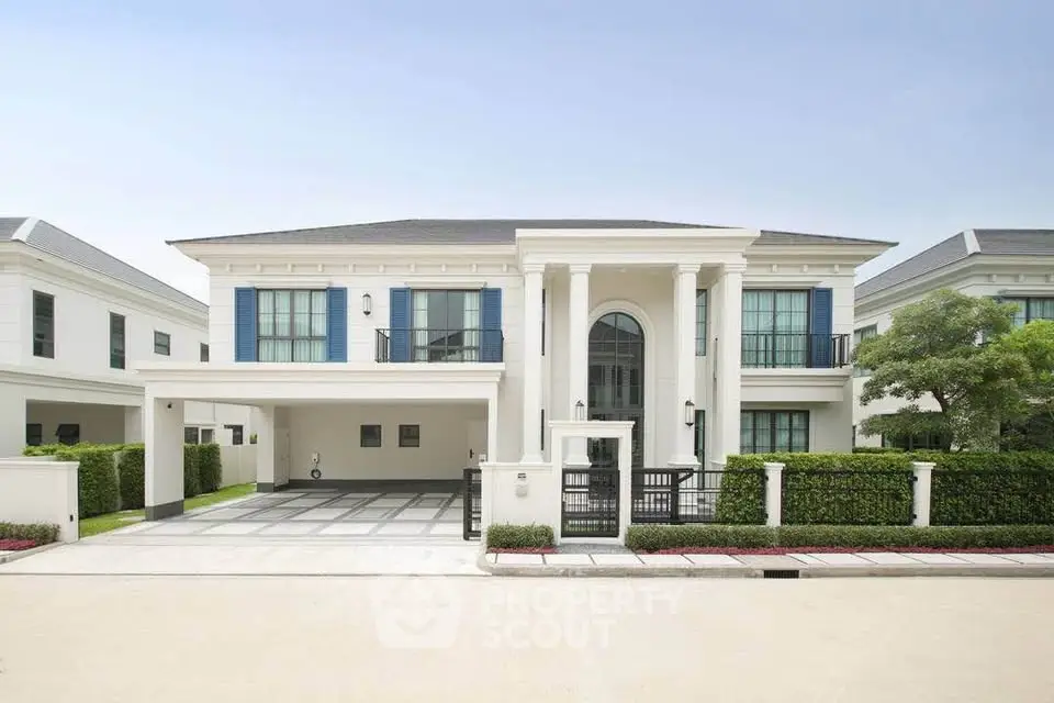 Luxurious modern villa with grand entrance and manicured landscaping in upscale neighborhood.
