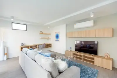 Modern living room with stylish furniture and wall-mounted TV, featuring a cozy ambiance and contemporary design.