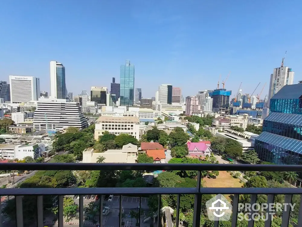 Stunning cityscape view from a high-rise balcony overlooking urban skyline and greenery.