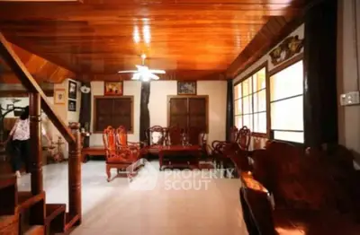Spacious living room with wooden ceiling and elegant furniture, perfect for family gatherings.
