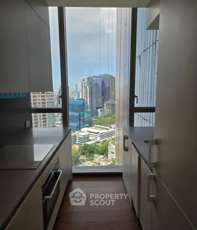 Modern kitchen with stunning city view from high-rise apartment window.