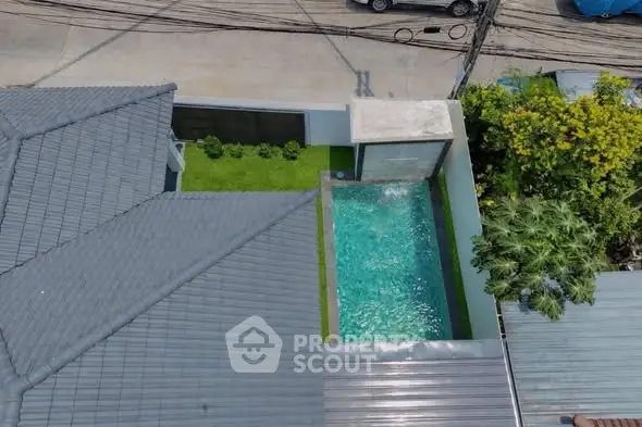 Aerial view of modern home with private pool and lush garden.