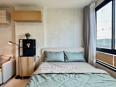 Modern bedroom with stylish decor and large window offering natural light.