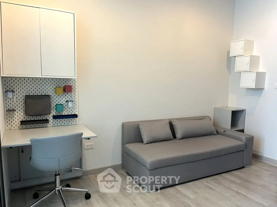 Modern study room with sleek desk, comfortable chair, and stylish sofa in minimalist design.
