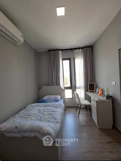 Cozy bedroom with modern decor and natural light, perfect for relaxation and study.