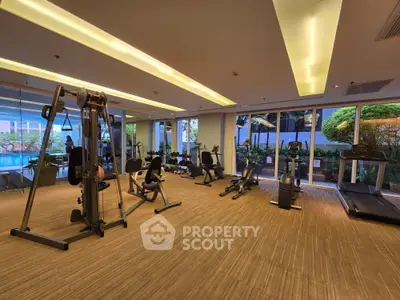 Spacious modern gym with state-of-the-art equipment and garden view, perfect for fitness enthusiasts.