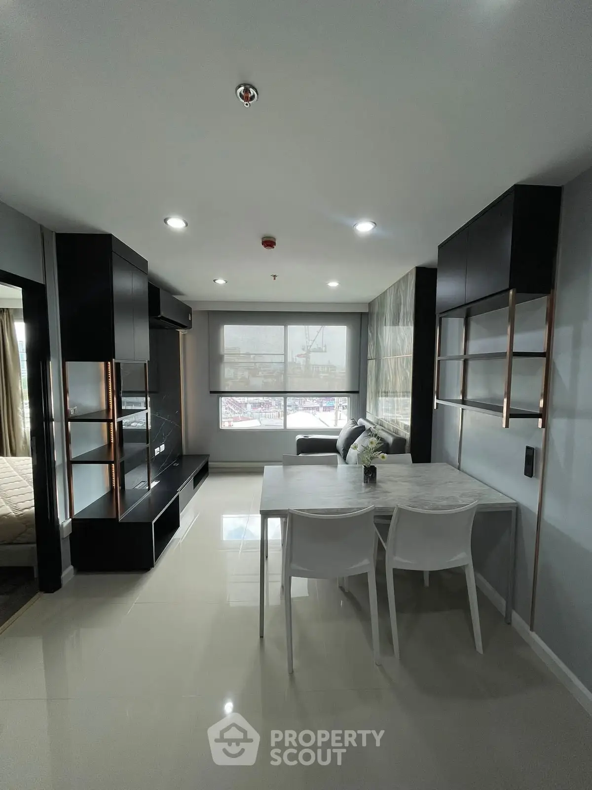 Modern living room with sleek design and dining area in a stylish apartment.