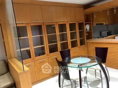 Modern kitchen with glass dining table and wooden cabinets