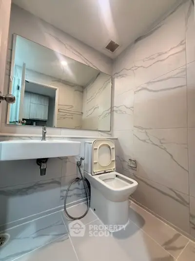 Modern bathroom with sleek marble tiles and contemporary fixtures.