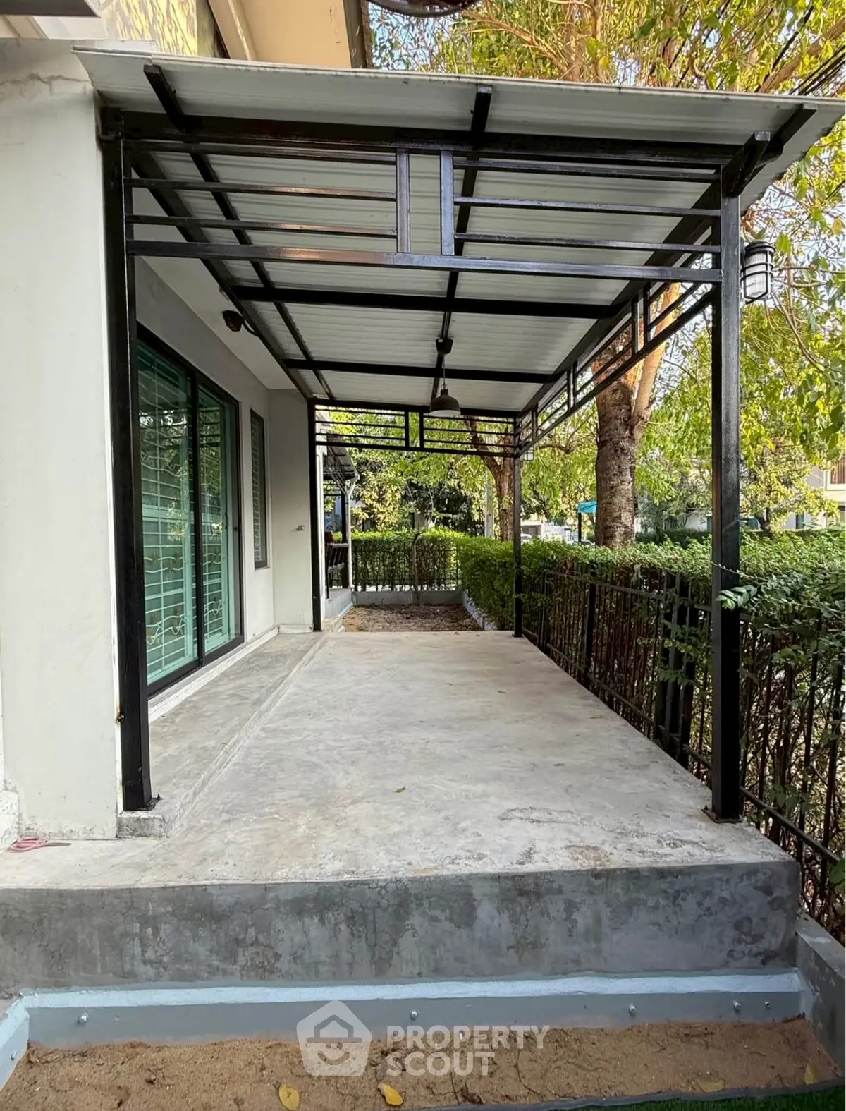Spacious outdoor patio with modern metal roofing and garden view, perfect for relaxation and entertainment.