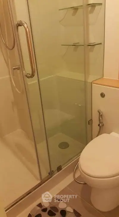 Modern bathroom with glass shower enclosure and sleek fixtures.