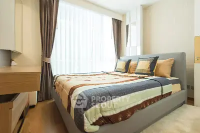 Cozy bedroom with modern decor and large window for natural light.