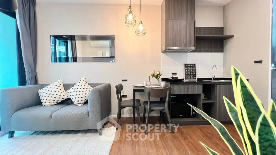 Modern living room with cozy seating and stylish kitchen in open layout apartment.