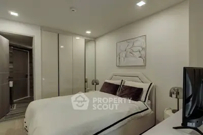 Modern bedroom with sleek design and cozy ambiance, featuring a stylish bed and ample closet space.