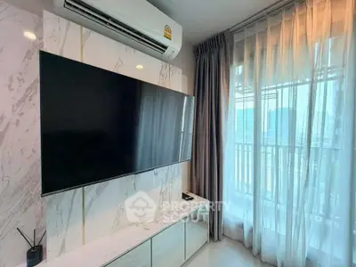 Modern living room with large TV and elegant curtains, featuring a sleek air conditioning unit.