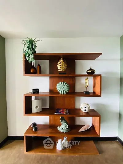 Stylish wooden shelving unit with decorative items in modern living room.