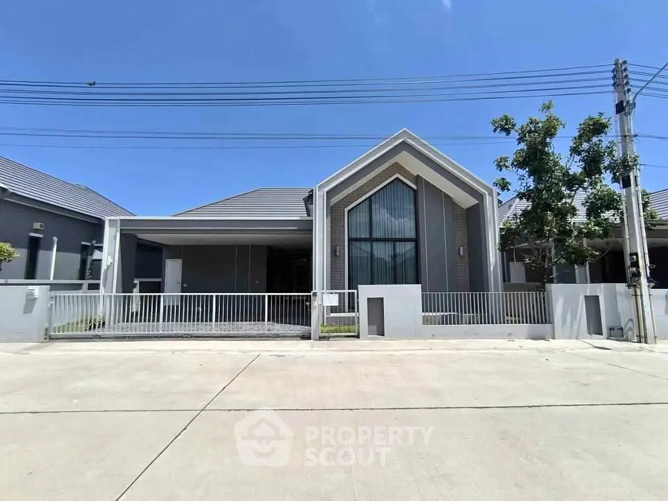 Modern single-story house with sleek design and large windows under a clear blue sky.