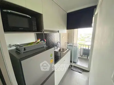 Compact modern kitchen with sleek appliances and balcony view