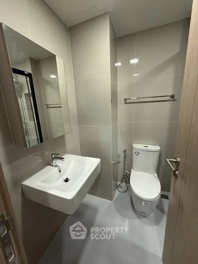Modern bathroom with sleek fixtures and neutral tiles, perfect for a contemporary home.