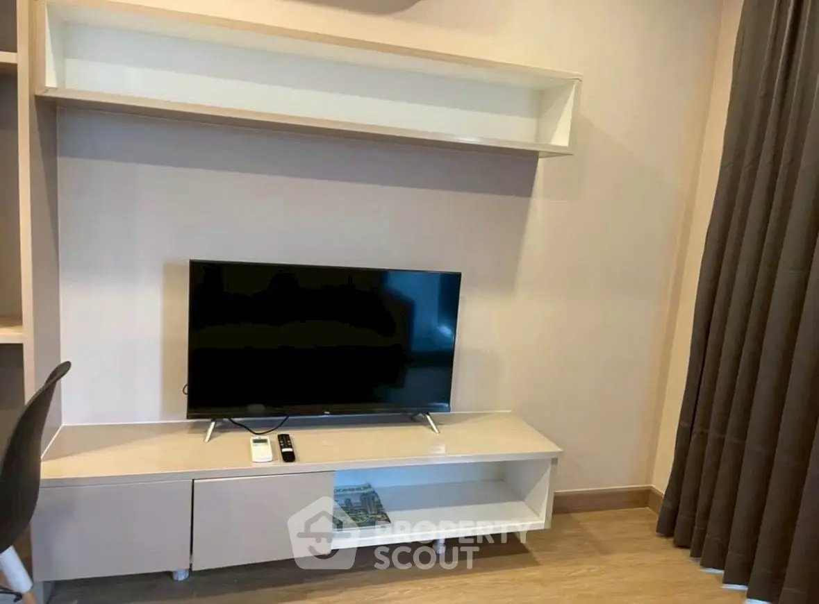 Modern living room with sleek TV stand and mounted shelf, perfect for cozy entertainment setup.