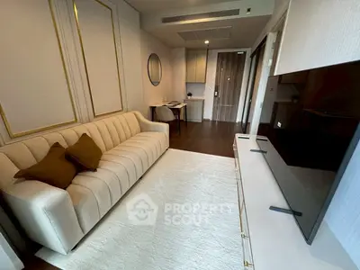 Modern living room with elegant sofa and large TV, featuring stylish decor and warm lighting.