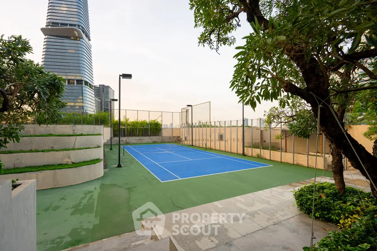 Luxurious urban tennis court with skyline view, surrounded by lush greenery and modern architecture.