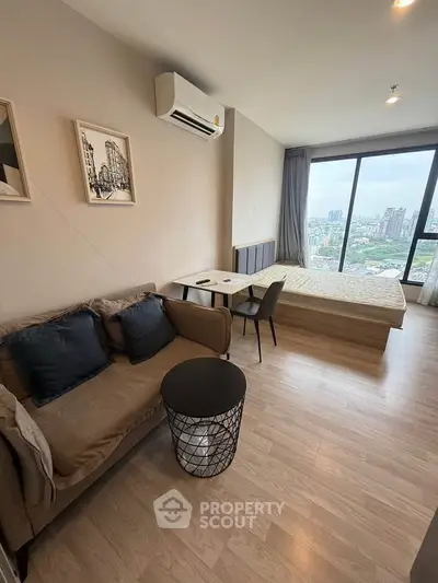 Modern studio apartment with city view, featuring cozy living area and stylish decor.