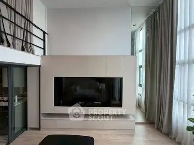 Modern living room with high ceilings and large windows in a stylish apartment.
