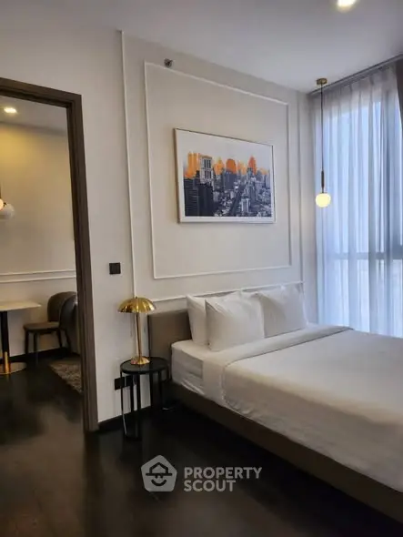 Modern bedroom with elegant decor and cityscape artwork, featuring floor-to-ceiling windows and stylish lighting.