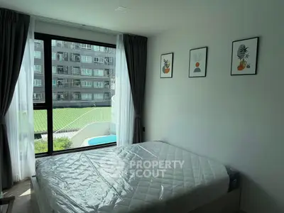 Bright bedroom with large window overlooking pool and modern decor