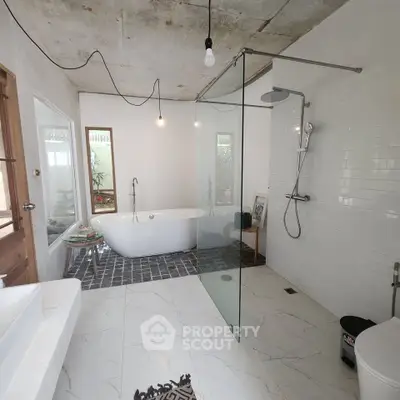 Spacious modern bathroom with freestanding tub and glass shower enclosure