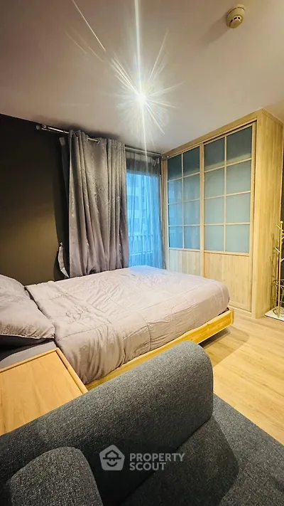 Cozy bedroom with modern decor and ample natural light, featuring a stylish wardrobe and comfortable bedding.