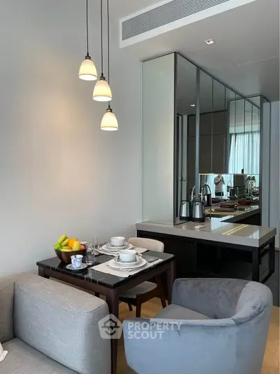 Modern dining area with elegant lighting and mirrored wall in a cozy apartment