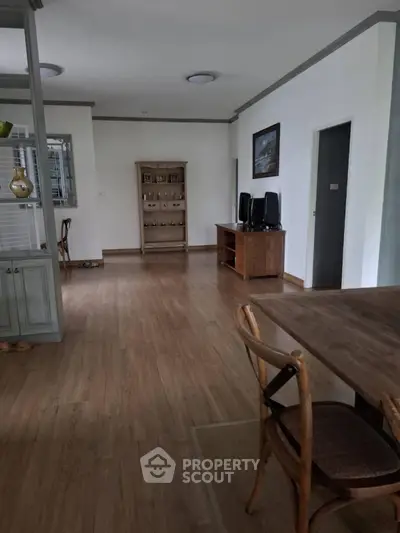 Spacious open layout living area with wooden flooring and elegant furniture