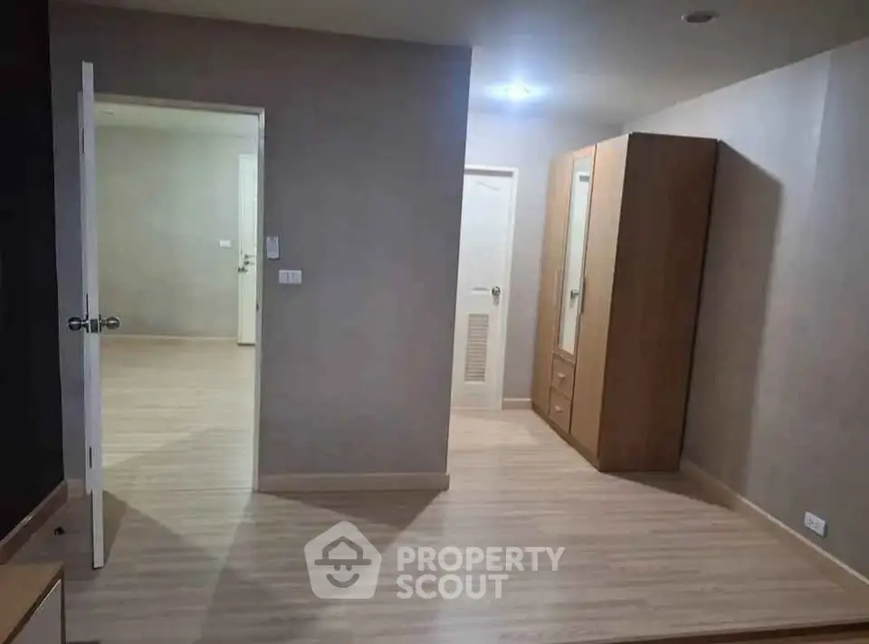 Spacious interior with wooden flooring and modern wardrobe in a well-lit room.