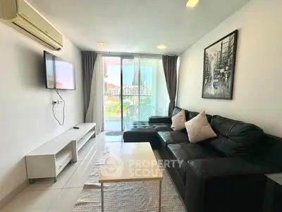 Modern living room with balcony view, sleek black sofa, wall-mounted TV, and stylish decor.