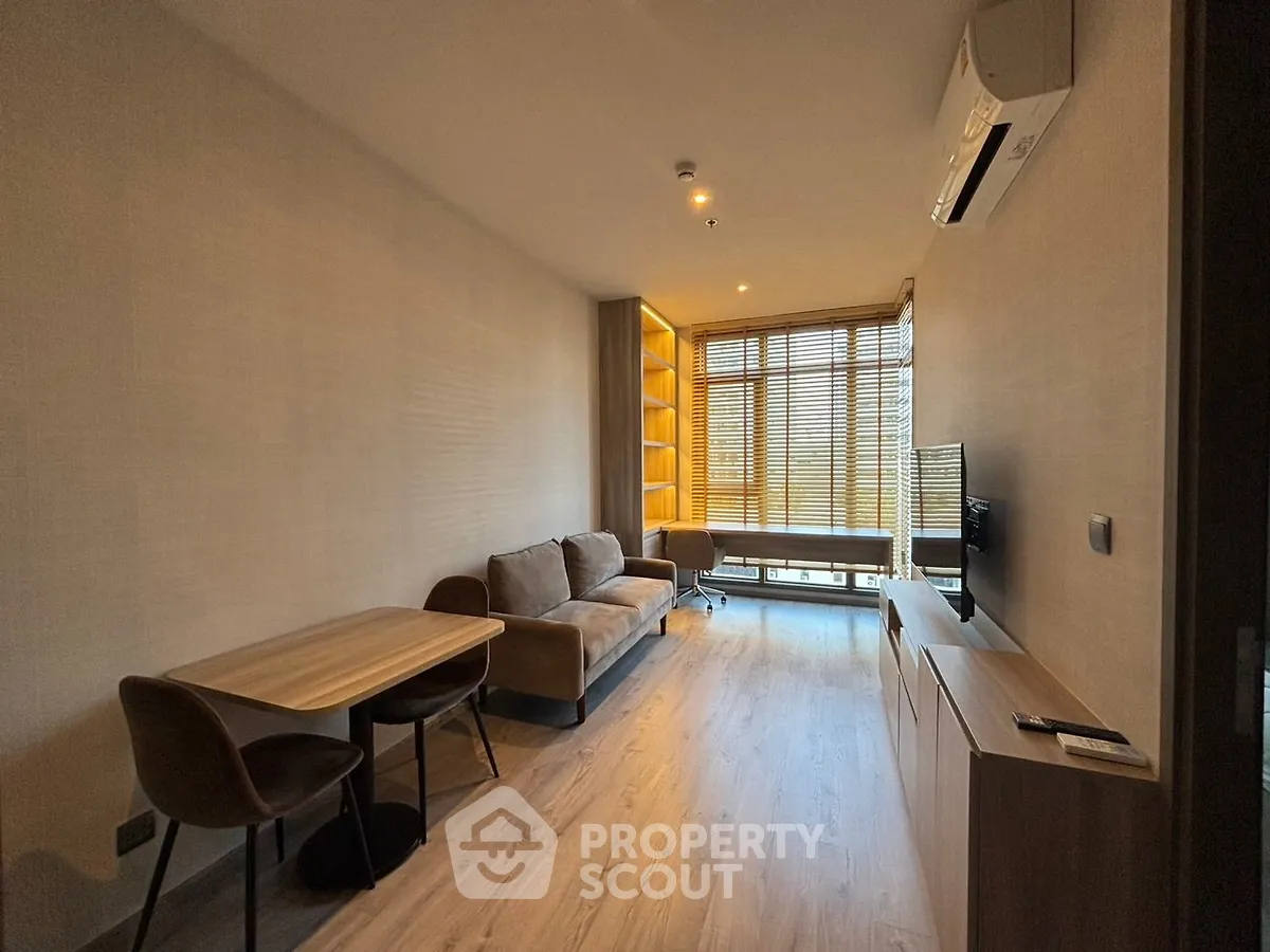 Modern living room with cozy sofa, dining table, and large window for natural light.