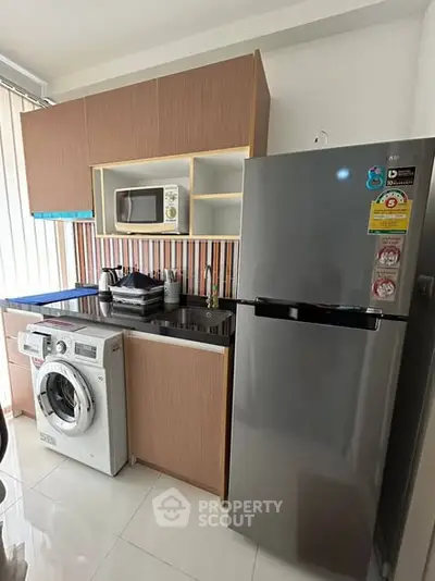 Modern kitchen with sleek appliances and stylish cabinetry in a contemporary apartment.
