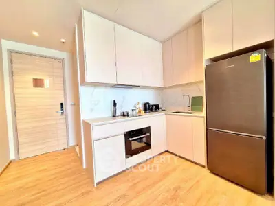 Modern kitchen with sleek cabinetry and built-in oven in a bright apartment