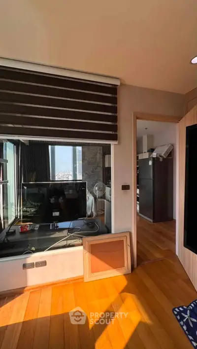 Modern living room with wooden flooring and large window offering city view