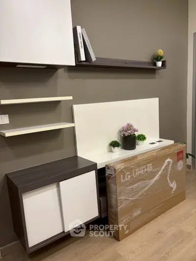 Modern living room with stylish shelving and new LG UHD TV in box