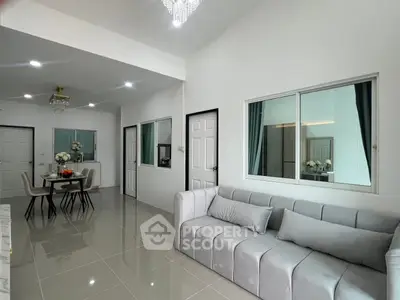 Modern living room with elegant gray sofa and chic dining area