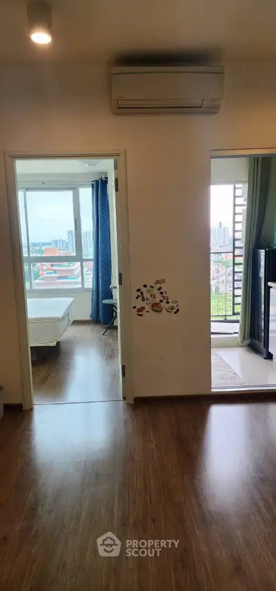 Spacious apartment with wooden flooring, air conditioning, and balcony view.