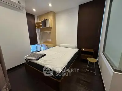 Modern bedroom with sleek design, featuring a comfortable bed and stylish workspace.